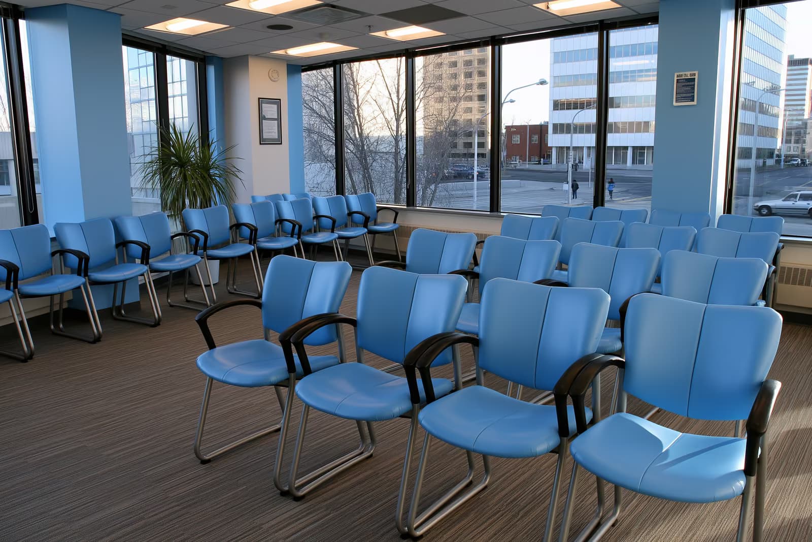 A quiet public office waiting area with rows of empty chairs and a service counter.