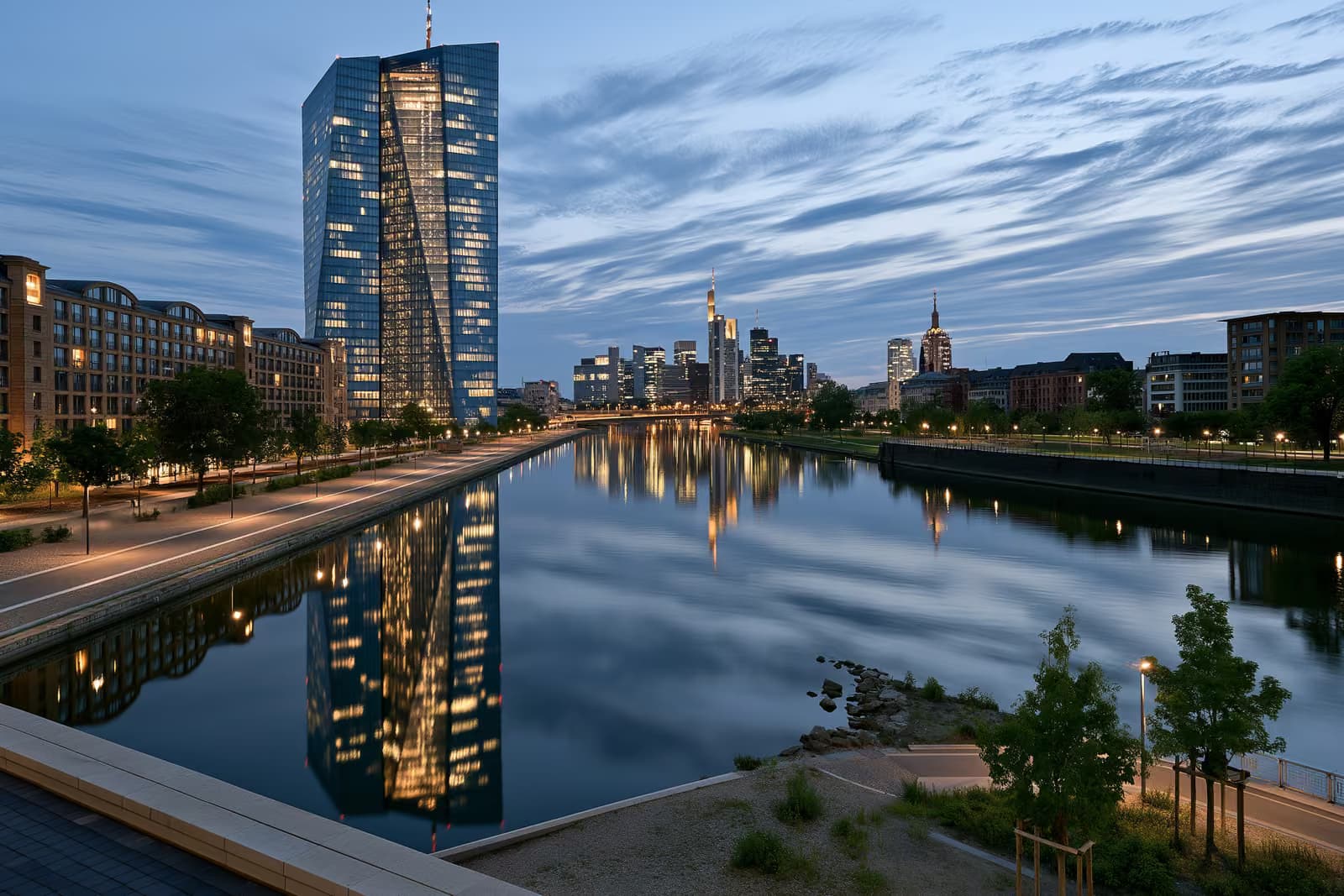 European Central Bank headquarters tower in Frankfurt against a bright summer sky.