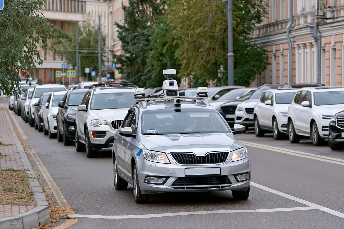 A camera-equipped municipal car scanning parked vehicles on a city street.