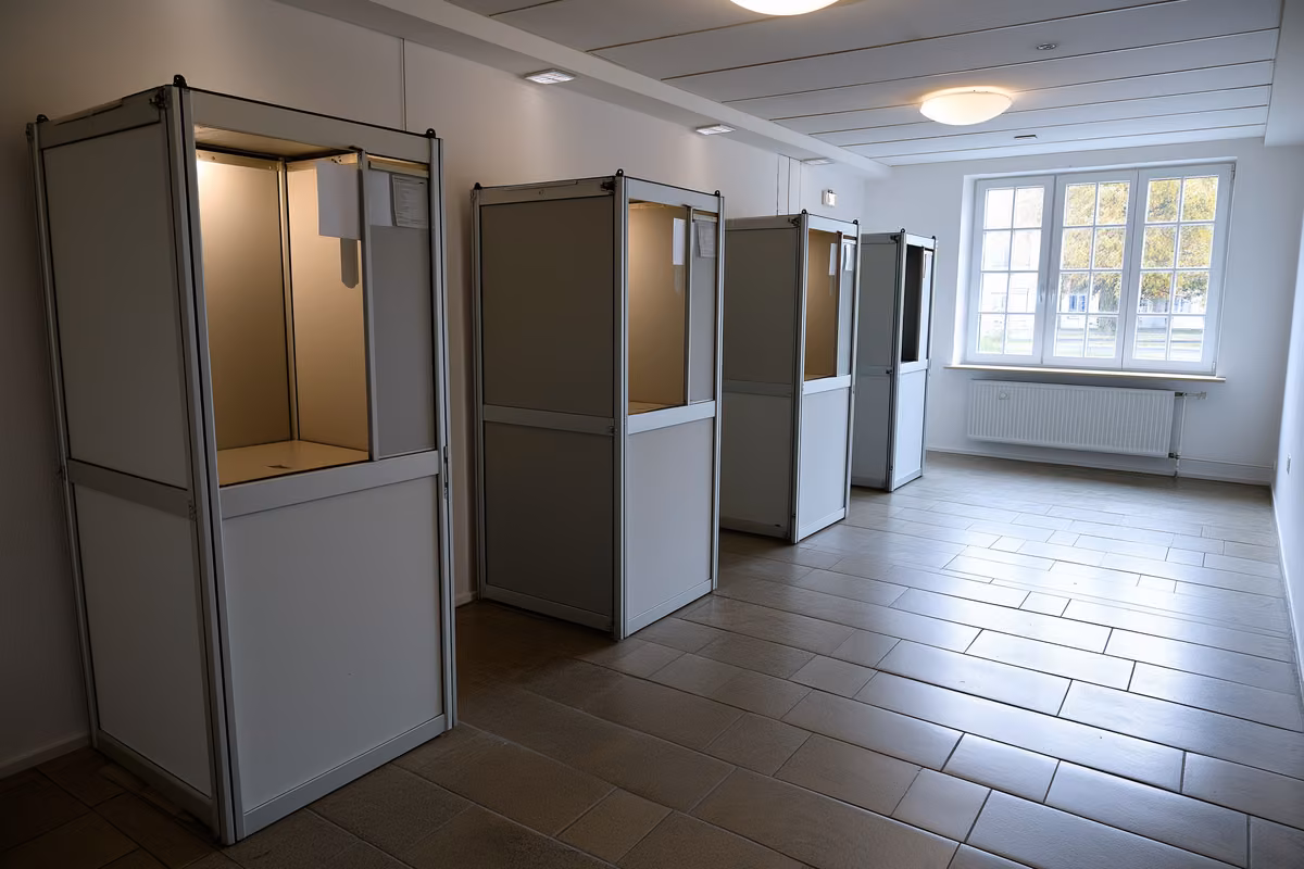 A blank polling booth in a plain German community hall used for elections.