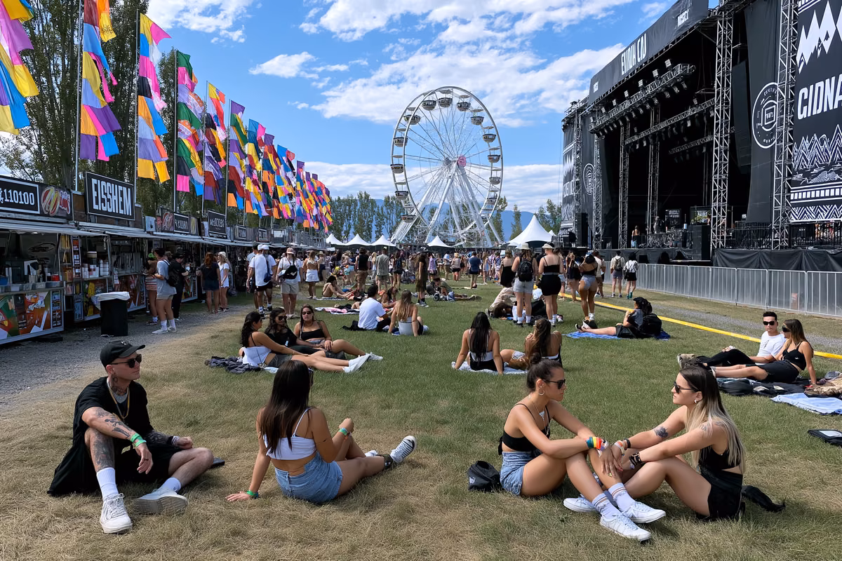 Festival grounds at Lollapalooza Berlin by day with colorful flags, food stalls and visitors relaxing on the grass
