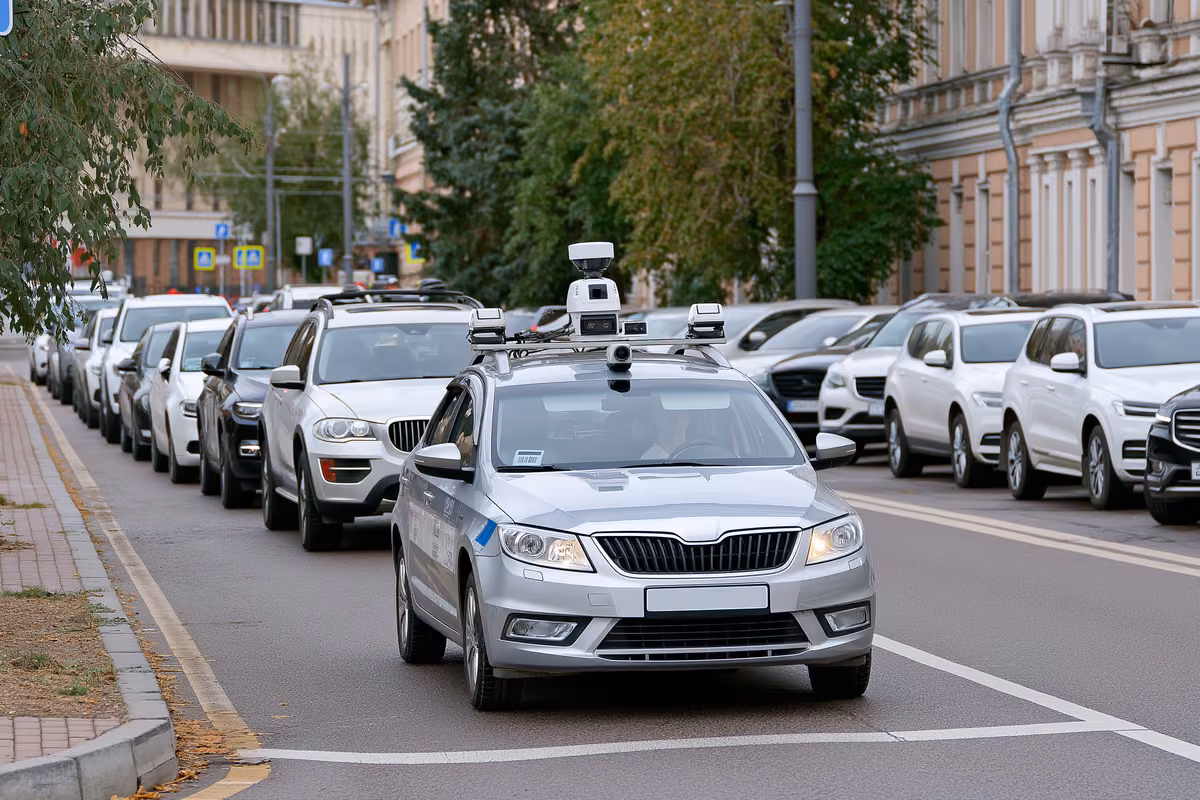 A camera-equipped municipal car scanning parked vehicles on a city street.